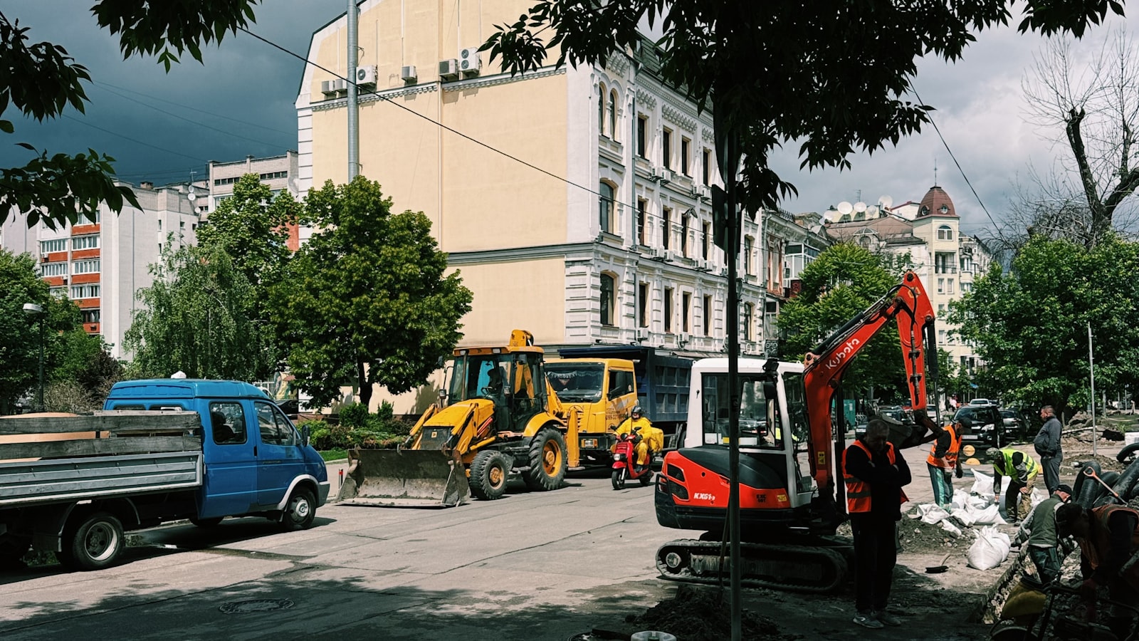 Heavy machinery working on an urban construction site - an excavator and backhoe loader at work, the kind of fleet this loan is financing.